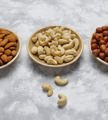 Assortment of nuts in ceramic plates. Cashew, hazelnuts, walnuts